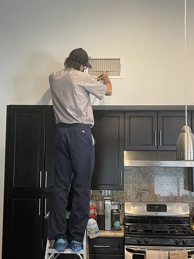 Technician inspecting an air vent during HVAC service in Cleveland